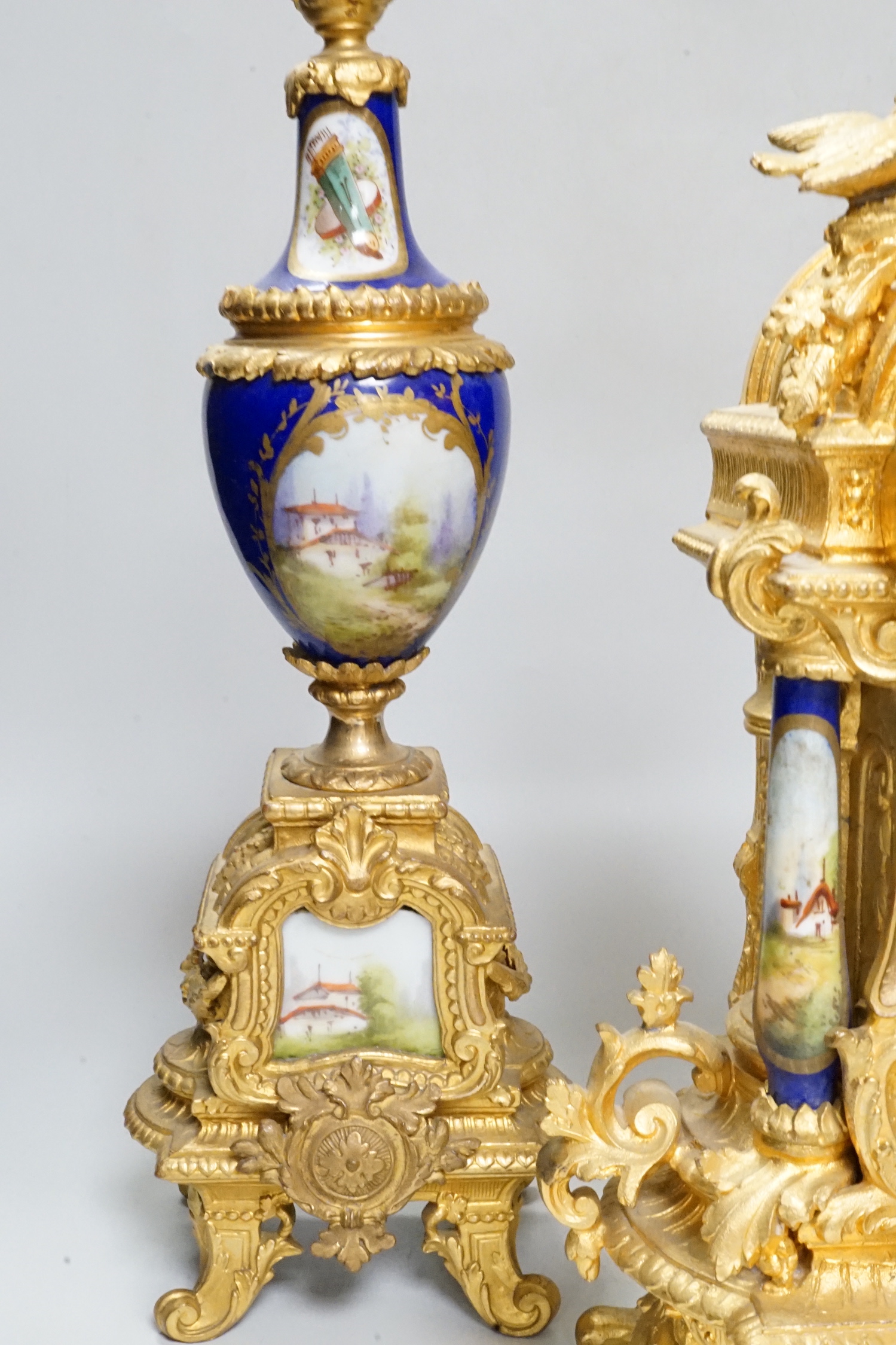 An early 20th century French gilt metal and porcelain set clock garniture, 42cm